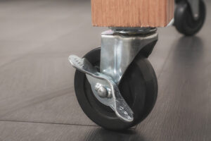 welding fixture table featuring flat, carbon steel surface with precision holes heavy-duty black frame, and locking red casters