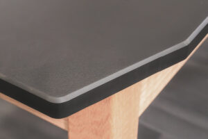 welding fixture table featuring flat, carbon steel surface with precision holes heavy-duty black frame, and locking red casters