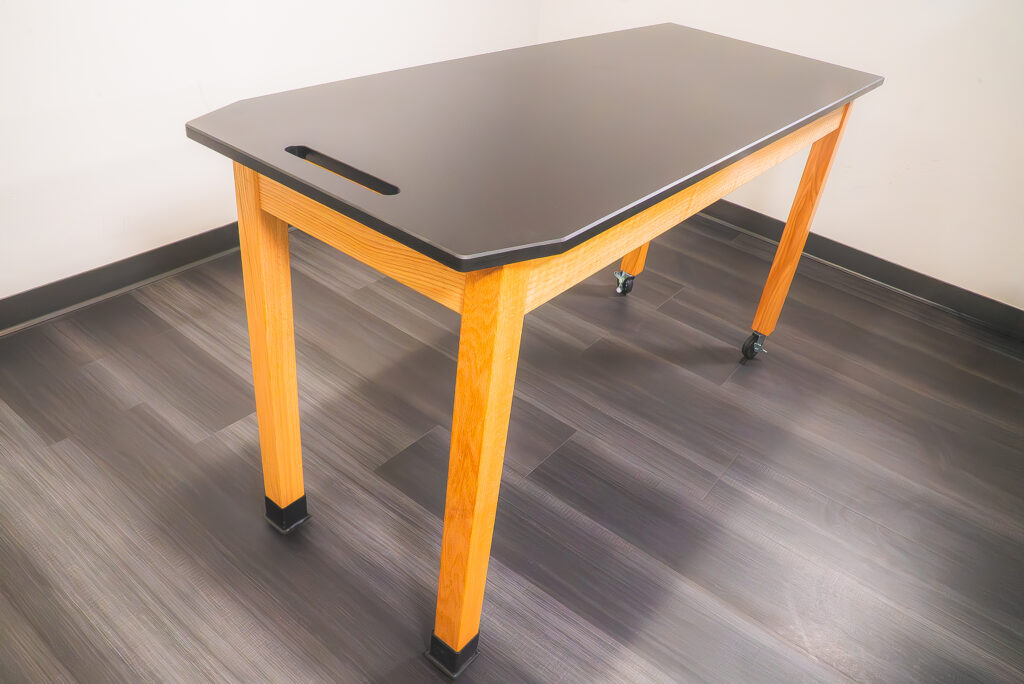 welding fixture table featuring flat, carbon steel surface with precision holes heavy-duty black frame, and locking red casters 