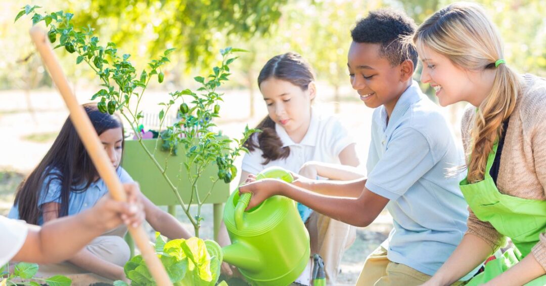 school aged kids growing a garden during class time